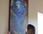 Kellen hanging her painting